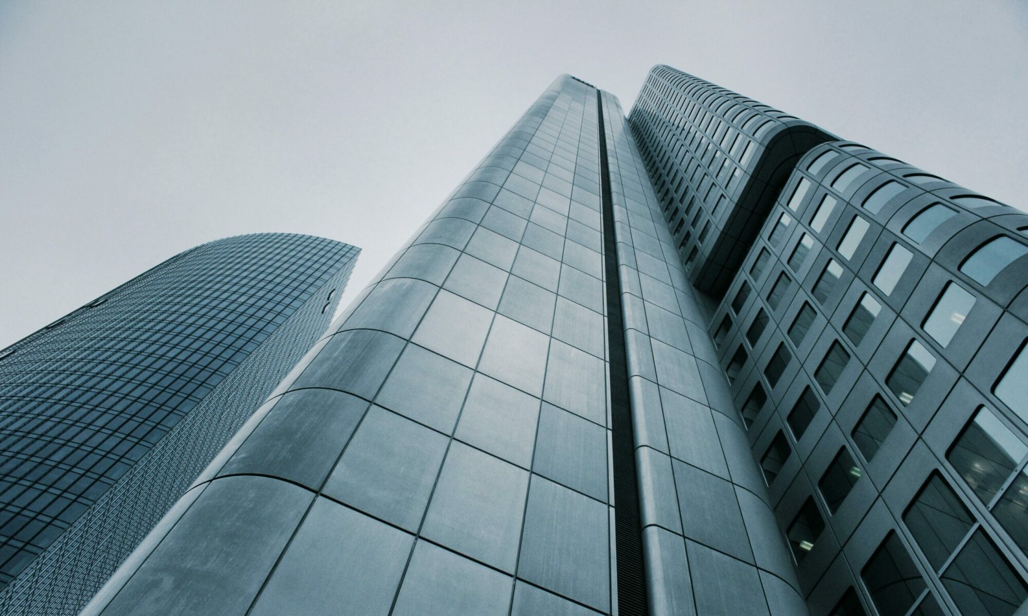 Low angle view of modern skyscrapers with glass and steel design. Perfect for corporate imagery.